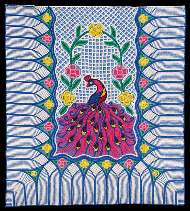 Colorful quilt with pink peacock in the middle with flowers surrounding it.