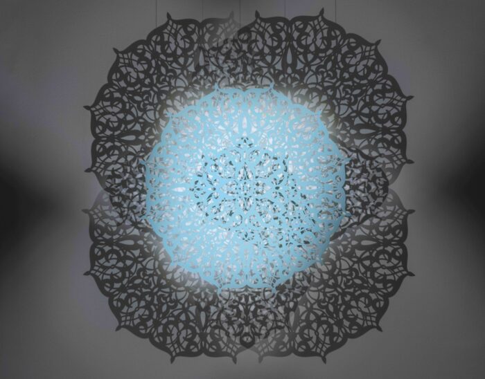 View looking up at an intricately cut, teal-colored light.