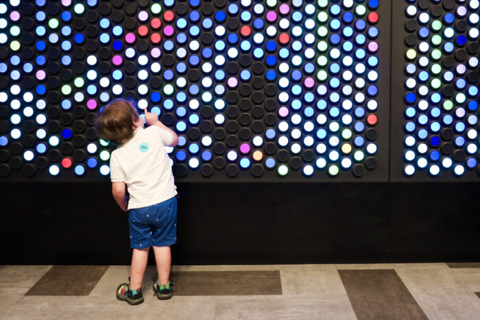 Toddler playing with colorful dials in ArtQuest