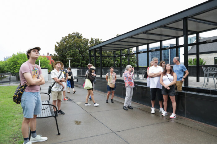 Tour group standing in the courtyard looking up at a building out of frame