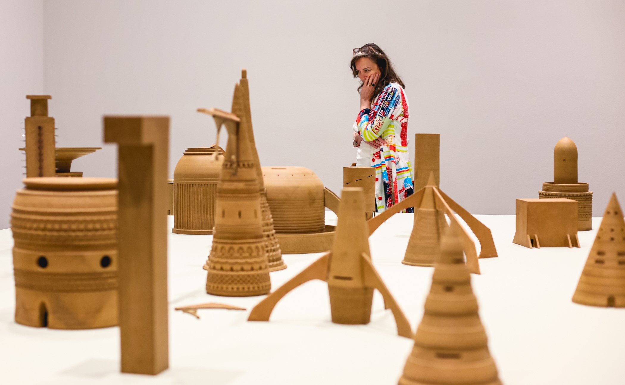 Woman looking at a table with various ceramic pieces