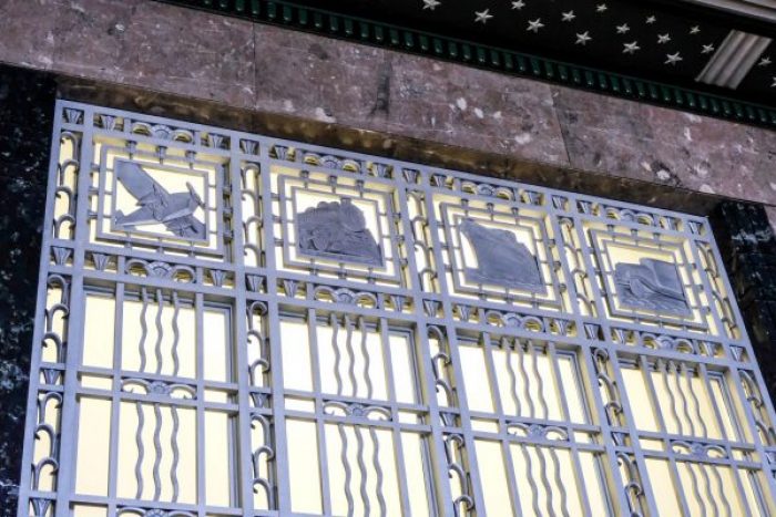 metal detail showing an emblem of a plane, train, boat, and car