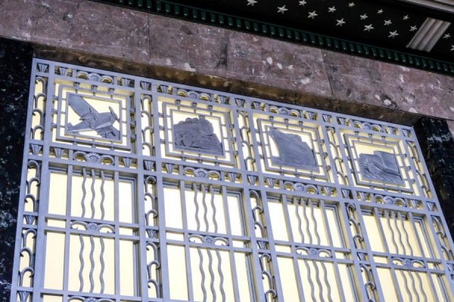 metal detail showing an emblem of a plane, train, boat, and car