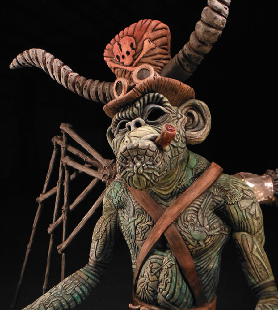 Monkey sculpture with carved patterns and a hat with a scull and crossbones and large horns