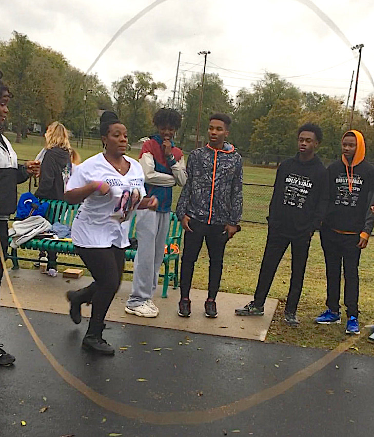 Woman stepping in to double dutch jump with onlookers watching