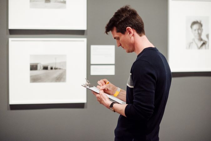 Young man writing on a pad in the galleries