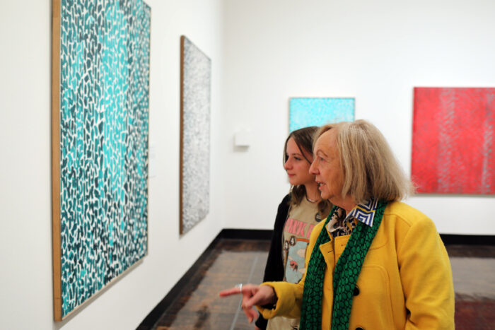 grandmother and granddaughter looking at a blue abstract work of art