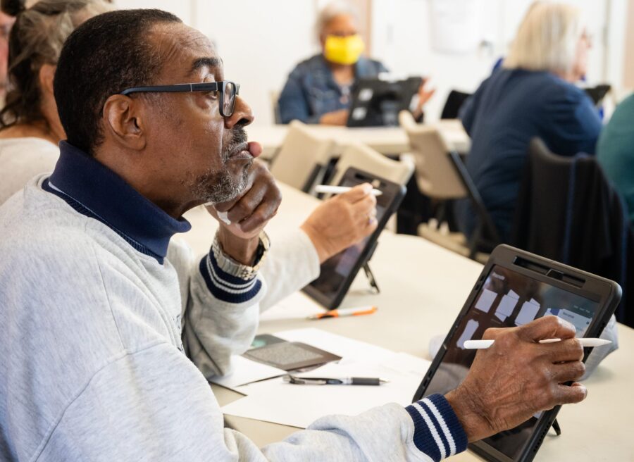 Man sitting at a table working on an iPad