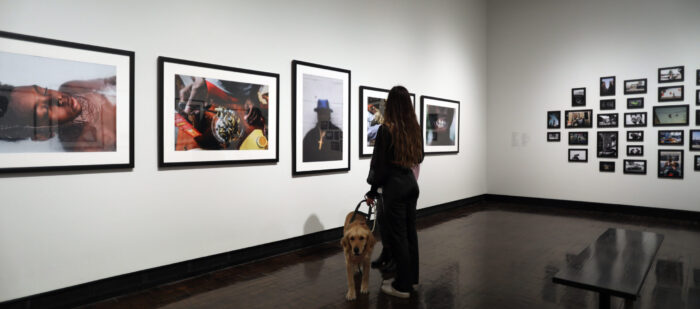 Mom and daughter looking at photographs with a service dog in the galleries