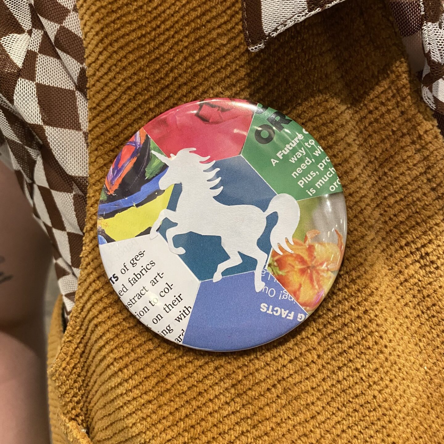 A colorful unicorn button on a shirt.